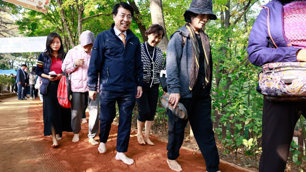 송파구가 구민 건강을 위해 송파나루공원과 오금공원에 맨발로 걷는 황톳길을 개장했다.사진은 서강석 구청장이 시민들과 황톳길을 걷는 모습.