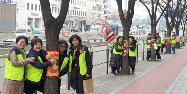 송파구 석촌동은 6일 석촌동 주변 700m 구간 가로수에 뜨개옷을 입히는 ‘그래피티 니팅’ 행사를 개최했다. 사진은 기념촬영 모습.
